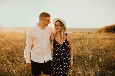 Smiling couple standing on grassy field