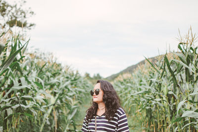 Mid adult woman wearing sunglasses while standing at farm