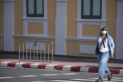 Full length of woman standing against building