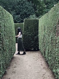 Rear view of woman standing on footpath