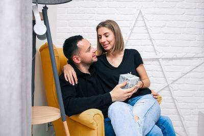 Young couple sitting in corridor