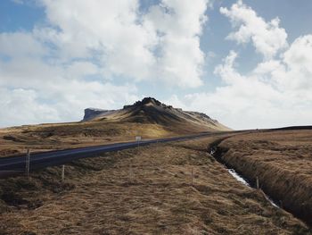 Road leading towards mountain against sky