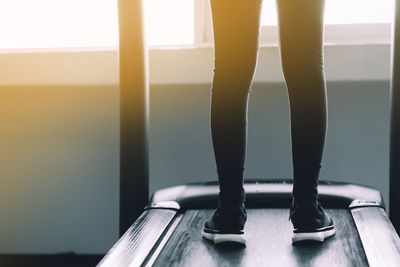 Low section of woman standing on seat