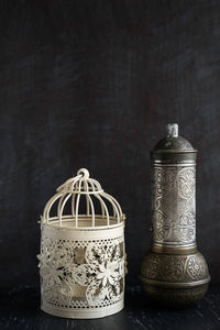 Close-up of metal container on table against black background