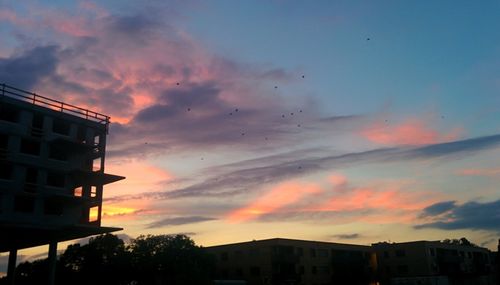 Low angle view of buildings against sky at sunset