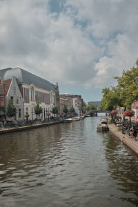 River by buildings against sky in city