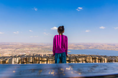 Rear view of woman looking at mountain against sky