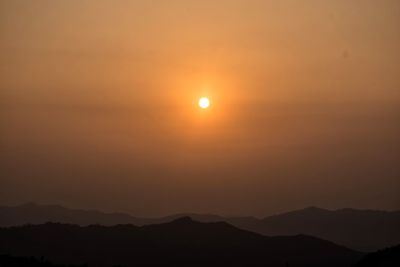 Scenic view of silhouette mountains against romantic sky at sunset