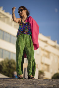 Full length of young woman standing against trees