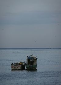 Boat sailing on sea against sky