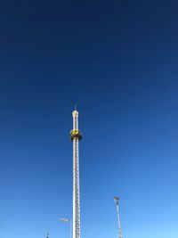 Low angle view of communications tower against blue sky