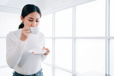 Young woman drinking coffee cup