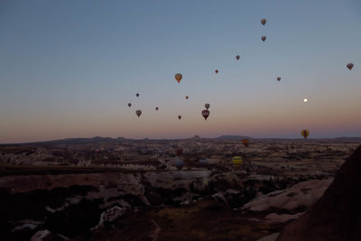 Silhouette hot air balloons over cappadocia against clear sky during sunset