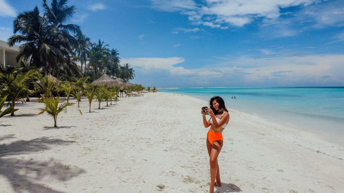 Full length of young woman standing on beach
