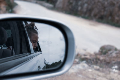 Reflection of girl on side-view mirror 