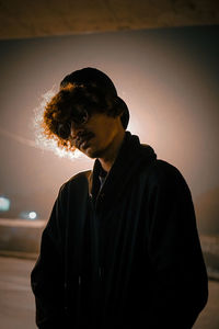 Side view of man looking away against sky during sunset