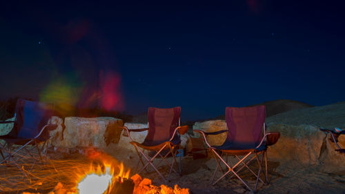 Panoramic view of bonfire on landscape against sky at night