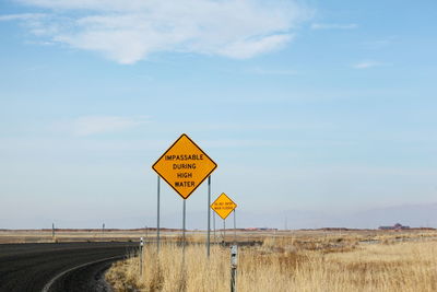 Information sign on road against sky