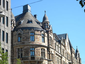 Low angle view of buildings against clear blue sky