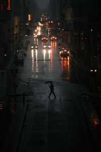 Illuminated city street during rainy season at night