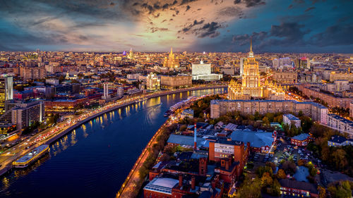 High angle view of illuminated city against sky during sunset