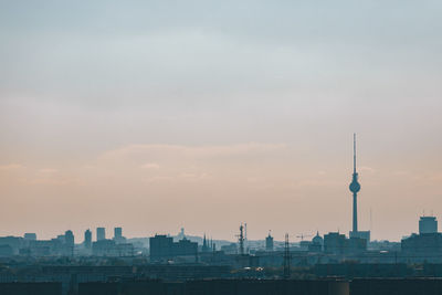 View of communications tower in city against sky