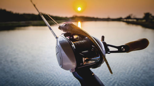 Close-up of a fishing bait casting rod and reel on lake