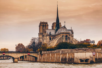 Arch bridge over river against buildings in city