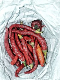 High angle view of red chili peppers on bed