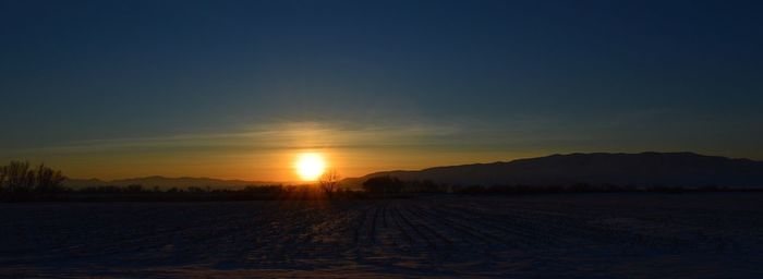 Scenic view of field against sky during sunset