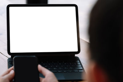Close-up of man using laptop on table