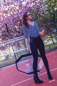 Full length of senior woman standing against plants