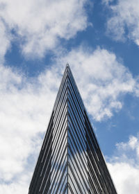 Low angle view of modern building against cloudy sky