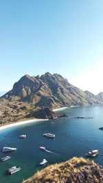 Scenic view of sea and mountains against clear sky