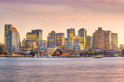 Modern buildings against sky during sunset in city