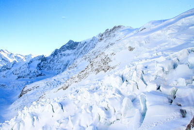 Scenic view of snowcapped mountains against clear blue sky