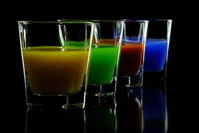 Close-up of colorful drinks against black background