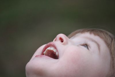 Close-up of cute girl with mouth open looking up