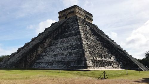 Low angle view of chichen itza against cloudy sky