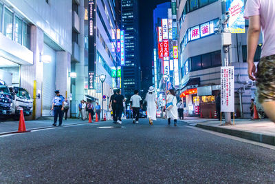 Surface level of people walking on road along buildings