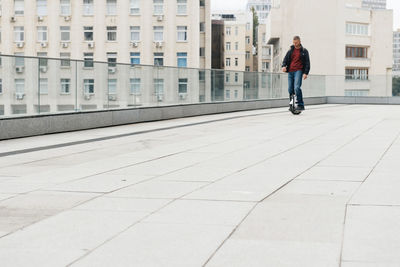 Man riding fast on electric unicycle on city street. mobile portable individual transportation