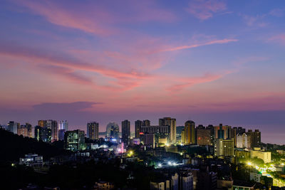 Illuminated buildings against sky during sunset