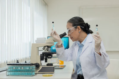 Female doctor examining chemical in laboratory