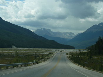 Country road against cloudy sky