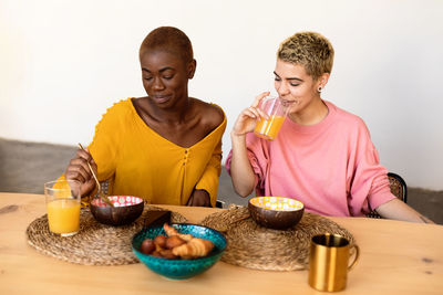 Lesbian couple eating breakfast at home