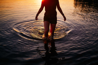 Low section of person standing in sea