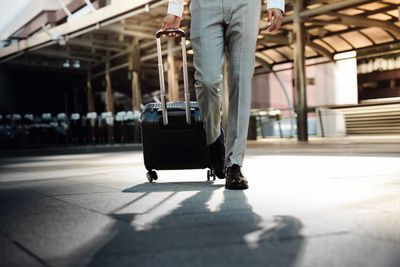 Low section of man walking at airport