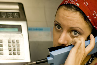 Close-up portrait of woman talking over payphone