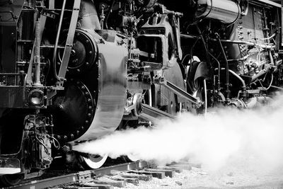 Close-up of steam train leaving smoke on railroad tracks