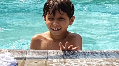 Portrait of shirtless boy swimming in pool